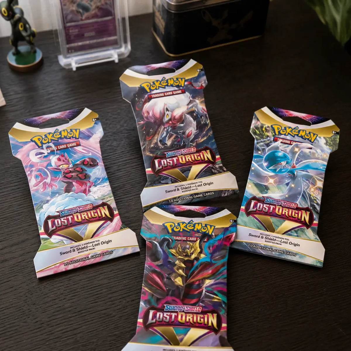 Pokemon Lost Origin Sleeved Booster – vier Packs auf Holztisch, sammlersicher verpackt von CardsRfun